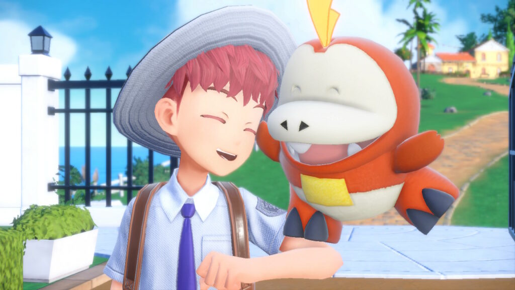 The player-character and his starter pokémon, Fuecoco, a smiling red crocodile the size and proportions of a stuffed animal, press their faces together and smile against a sunny background in the new game, Pokémon Scarlet and Violet.