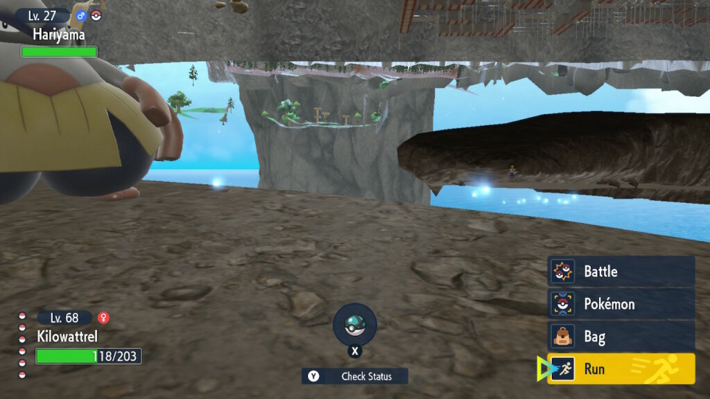 A screenshot of Pokémon Scarlet and Violet, taken from a position where the camera shouldn’t normally be, showing faraway caves and trees and other structures, as well as a patch of bright blue sky in the middle everything, all of which should normally be hidden behind the ground and walls.