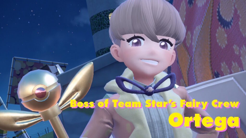 Ortega, the boss of Team Star’s Fairy Crew. He’s a young boy with rosy cheeks and platinum hair in a bowl cut, wearing a gaudy cream-and-pastel-pink suit jacket and wielding a golden scepter whose tip is shaped like a pokéball atop a large bow.