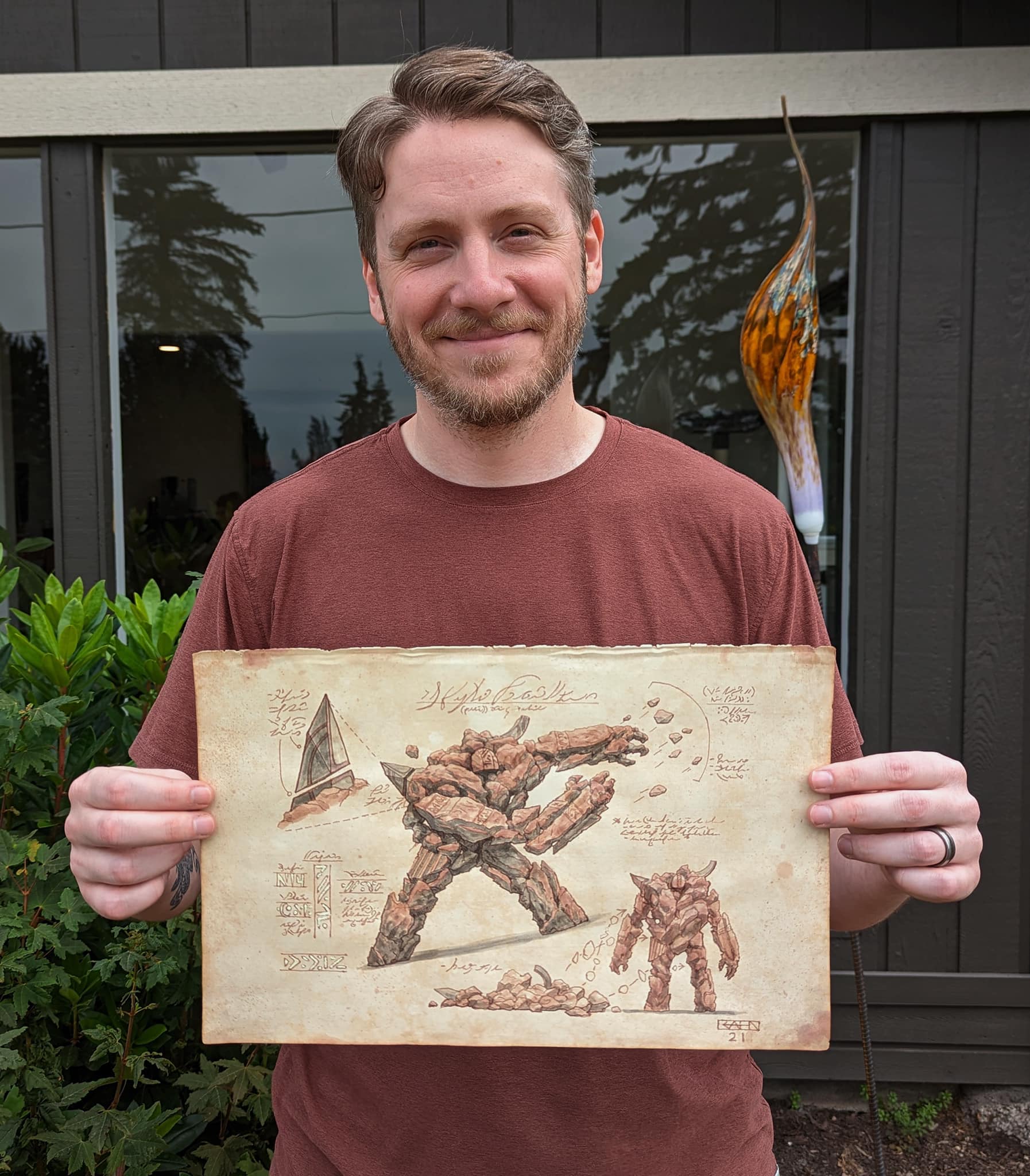 Chris Rahn posing with his Lodestone Golem illustration.