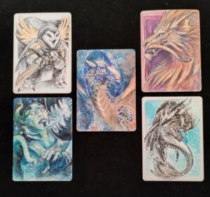A selection of five artist proofs from Cara Mitten. They depict anything from a sword-bearing owl to a manticore.