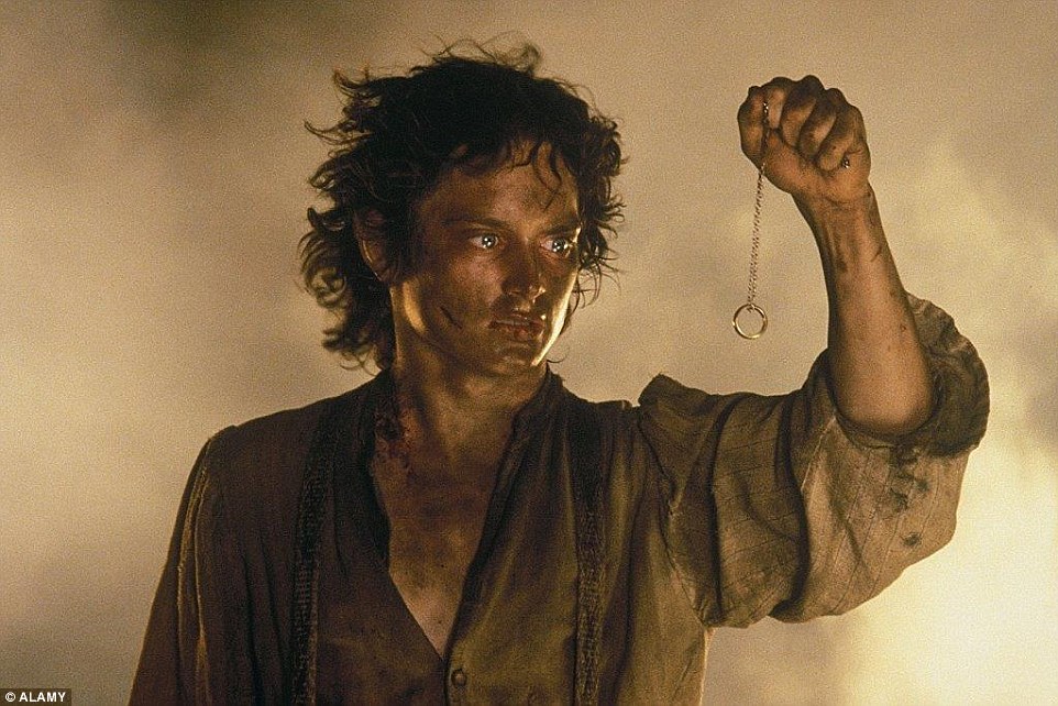 Elijah Wood as Frodo Baggins in the film Lord of the Rings: Return of the King. Frodo is holding The One Ring on a chain, contemplating whether or not he should actually throw it into Mount Doom.