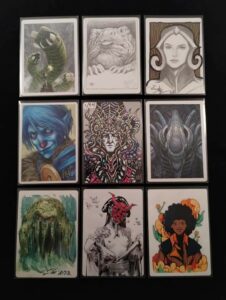 A 3x3 stack of Magic: The Gathering artist proof backs, each depicting fantasy characters, ranging from Dune sand wurms to Liliana Vess of MTG.
