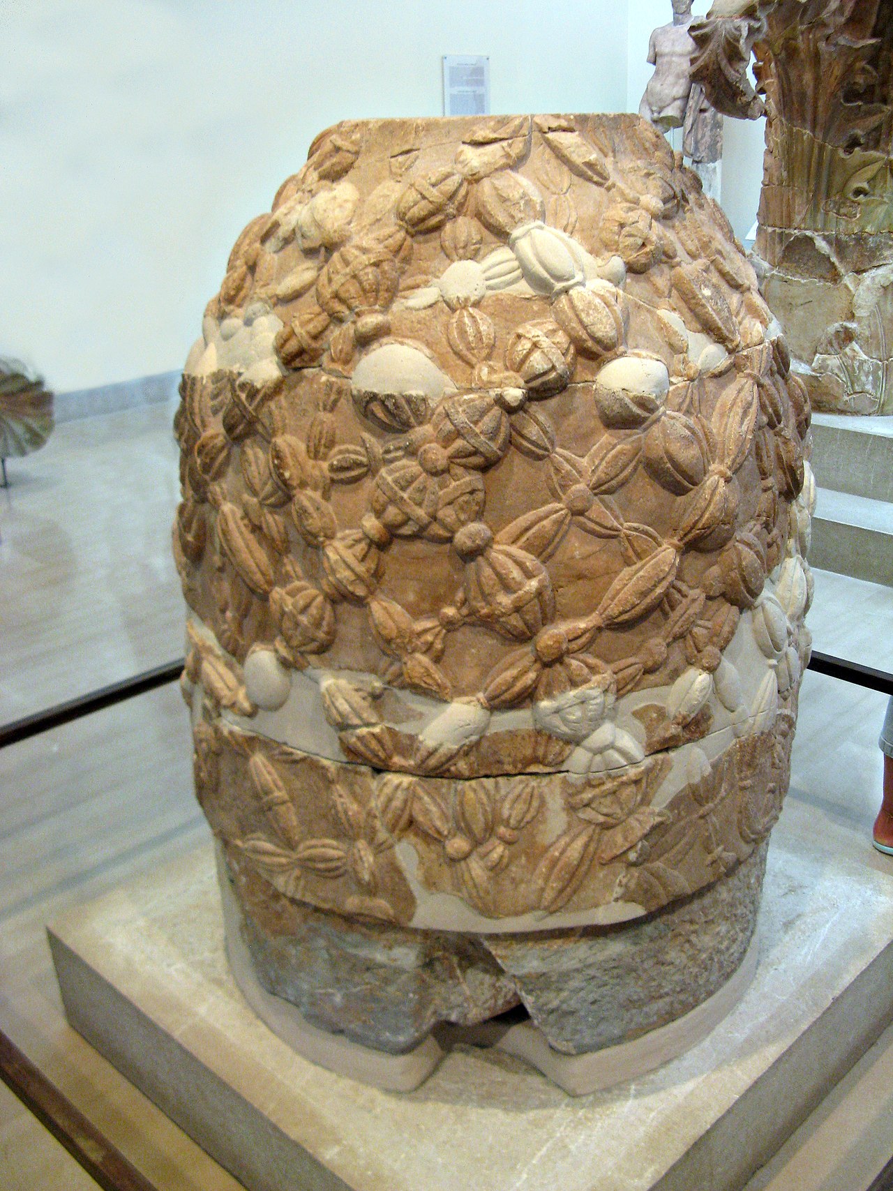 The Omphalos of Delphi, a religious stone artifact with a carving of a net and a hollow center. 