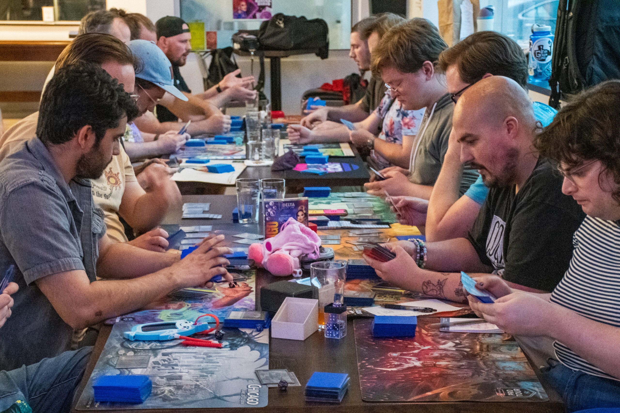 A side profile of a large group of people playing Magic at a brewery