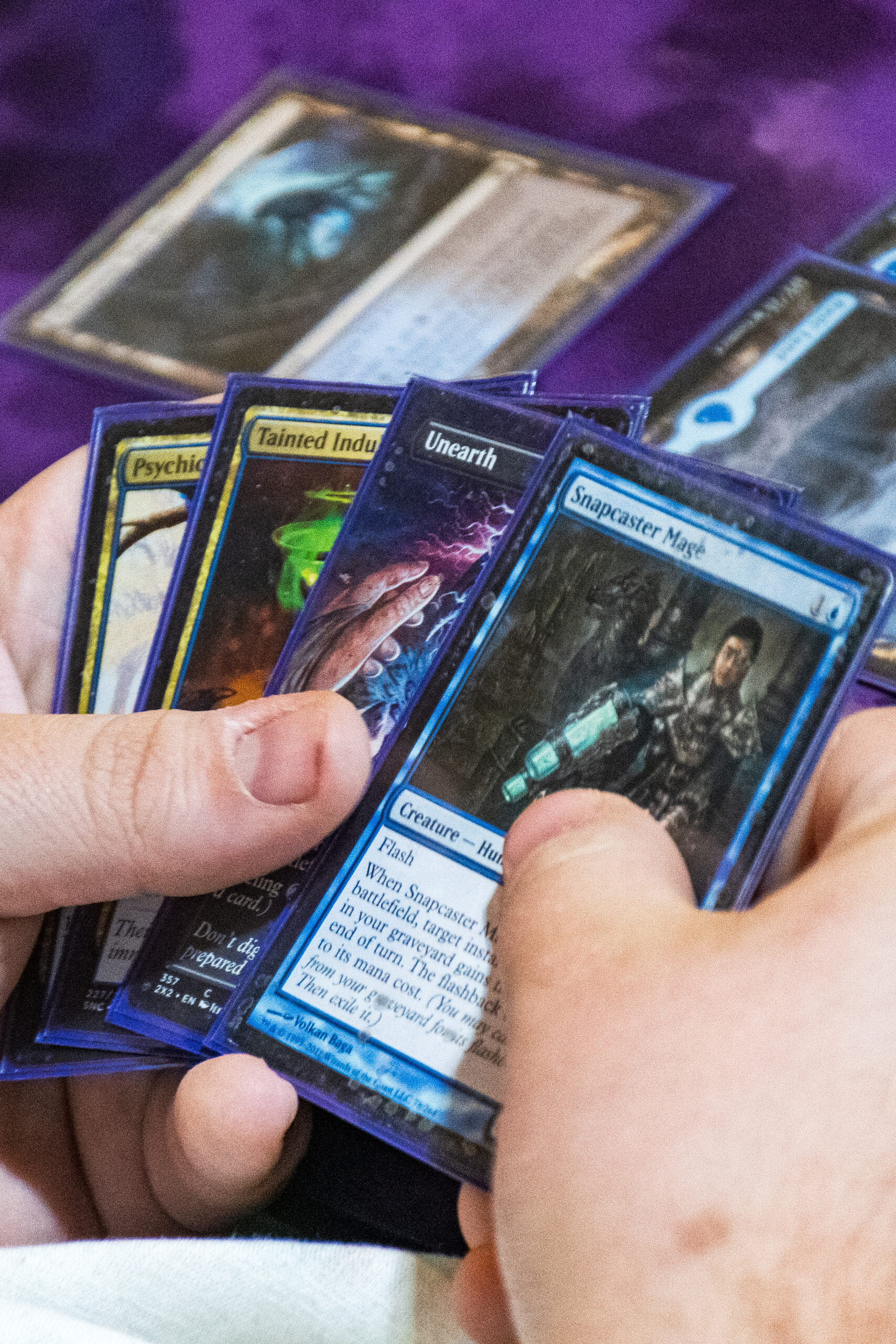 Hands holding Magic cards, during a game