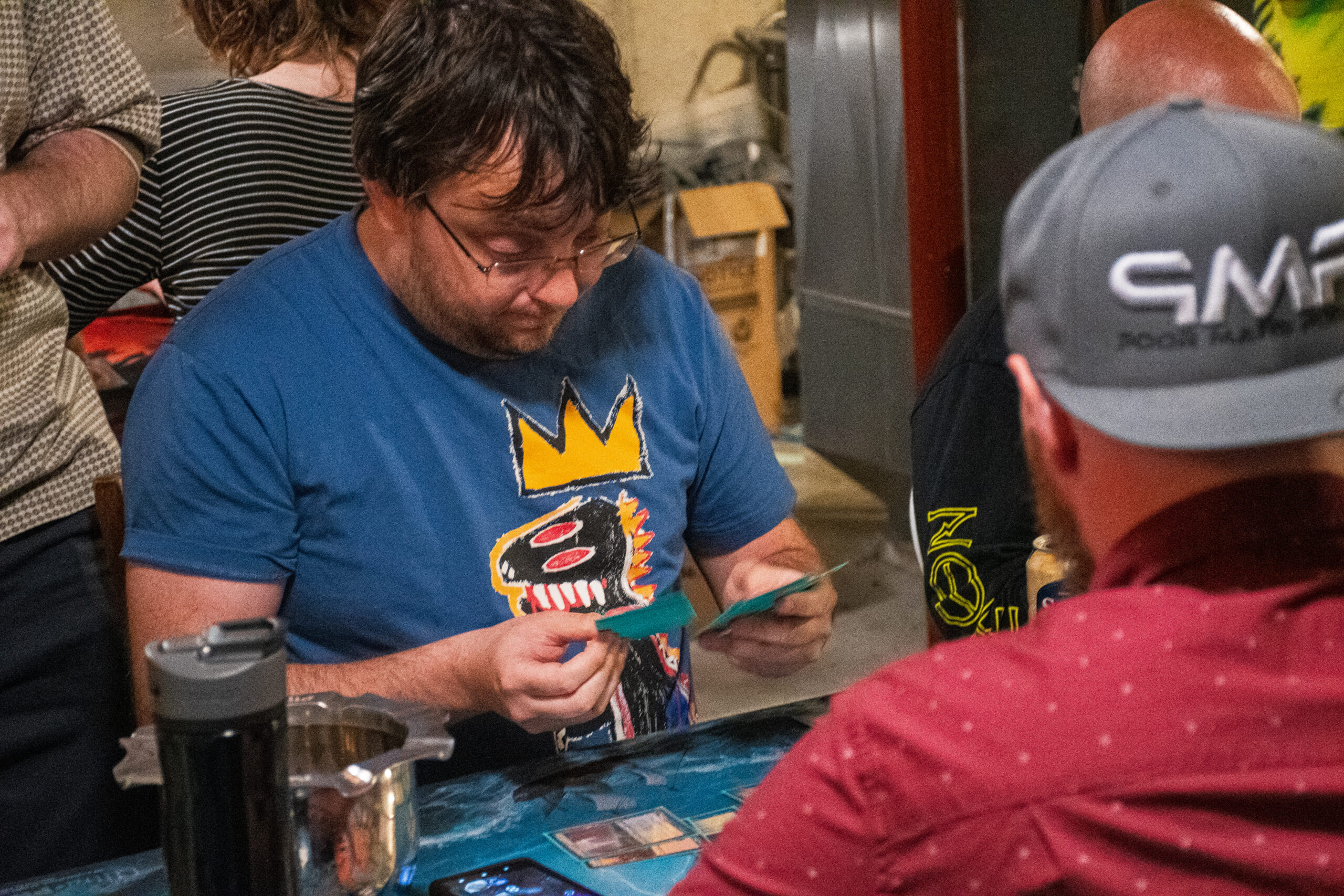 A Magic player looks at their hand of cards in disbelief