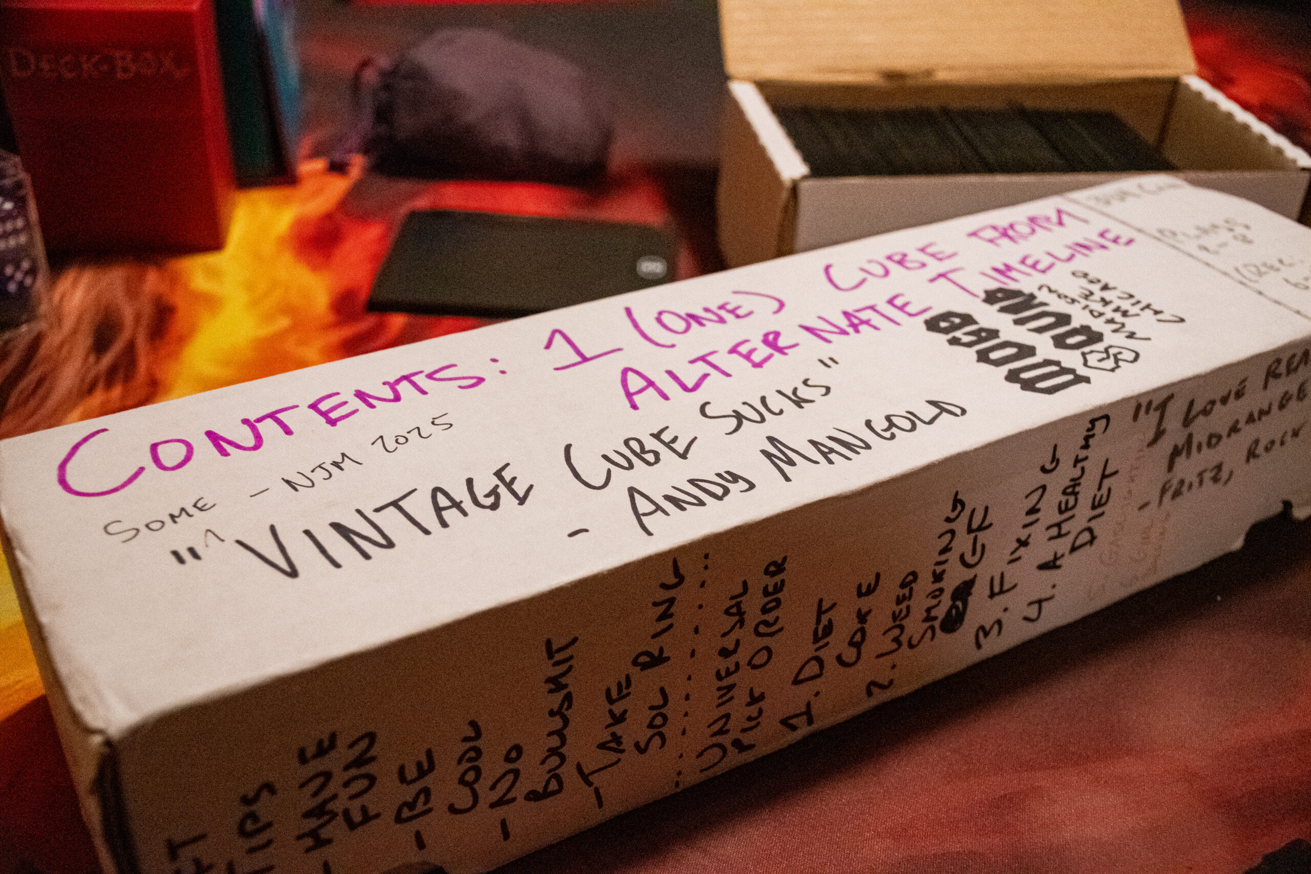 A long white box of Magic cards, featuring messages handwritten in sharpie across it from various people