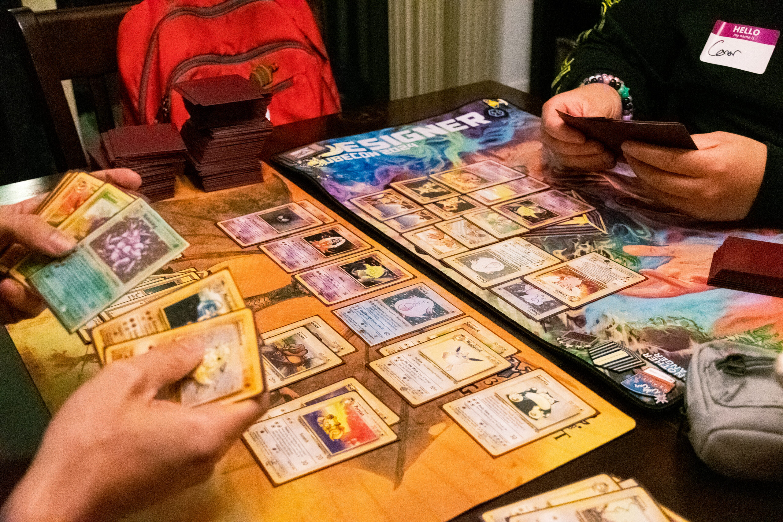 Two people building Pokemon TCG decks on a dining room table