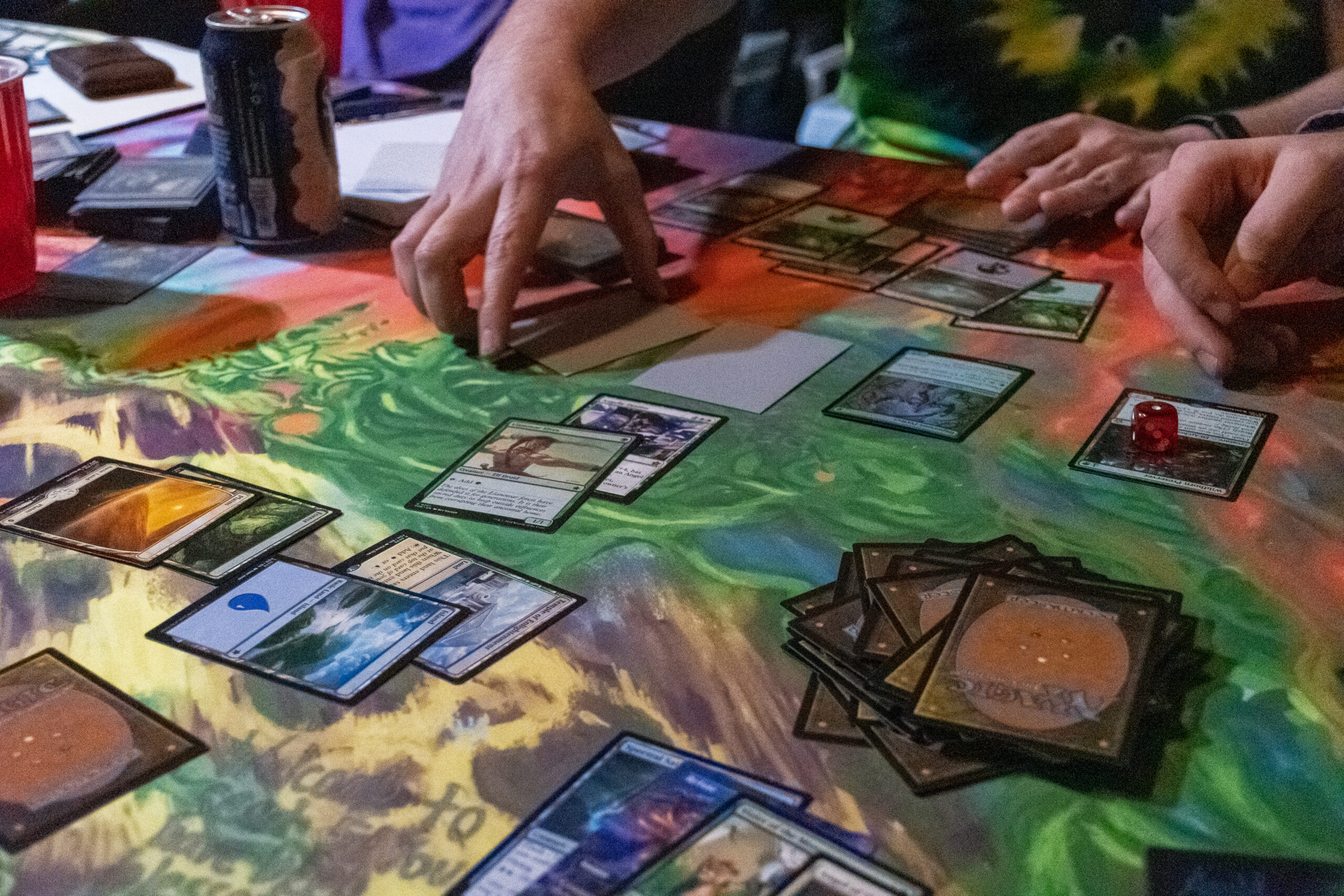 Hands move unsleeved Magic cards on a table