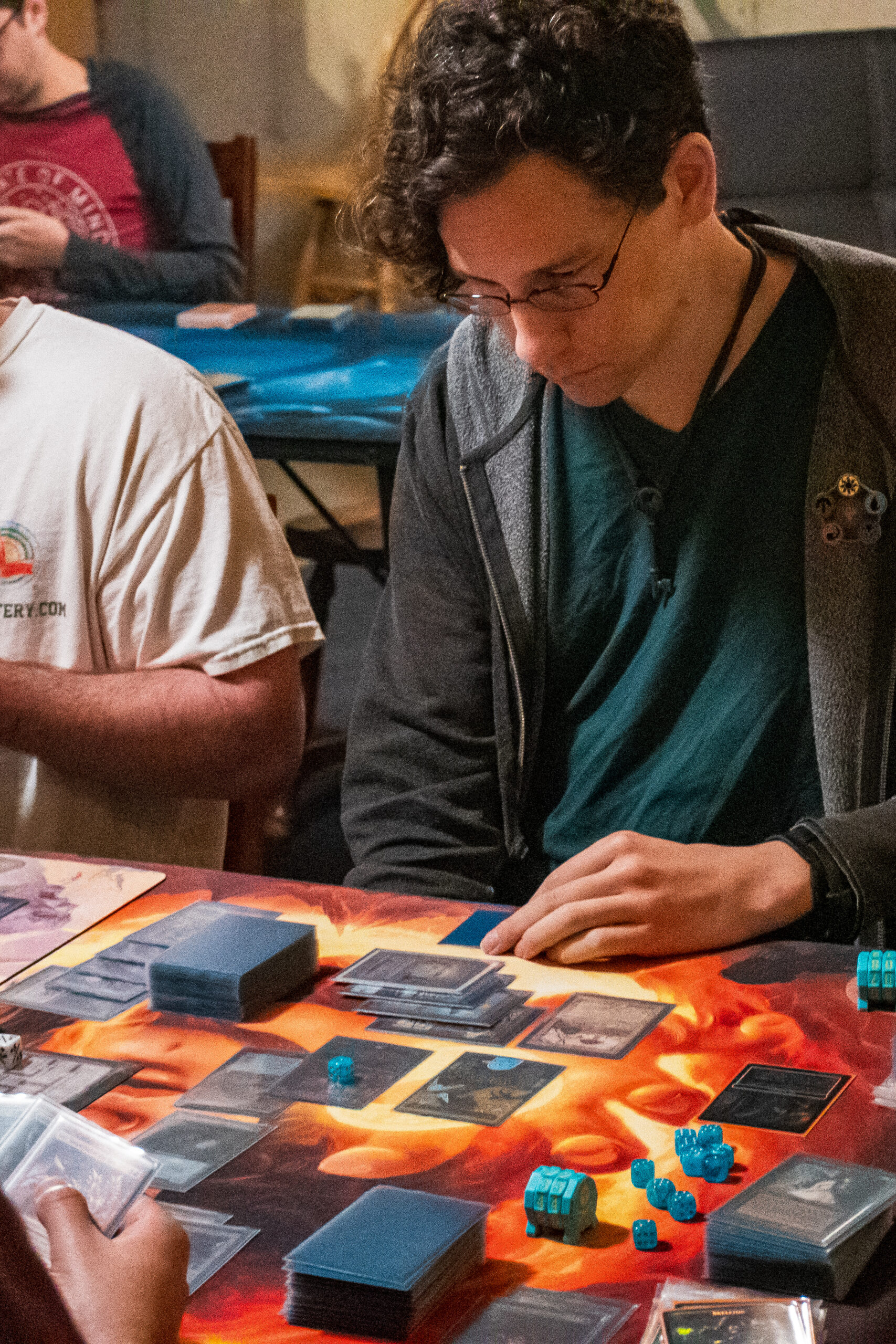 A Magic player looks downward at the cards in front of them